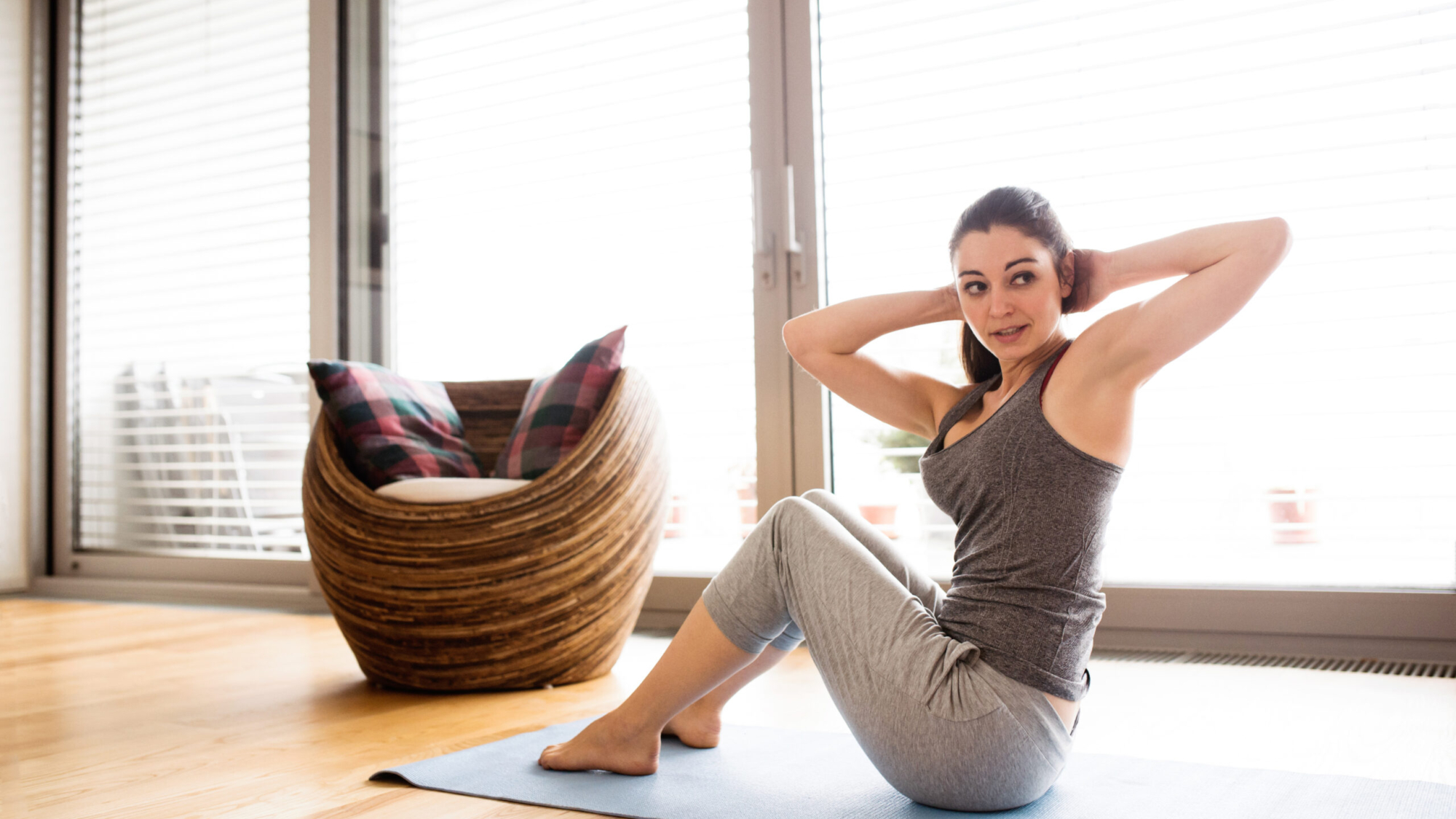 Young woman exercising at home, doing crunches.